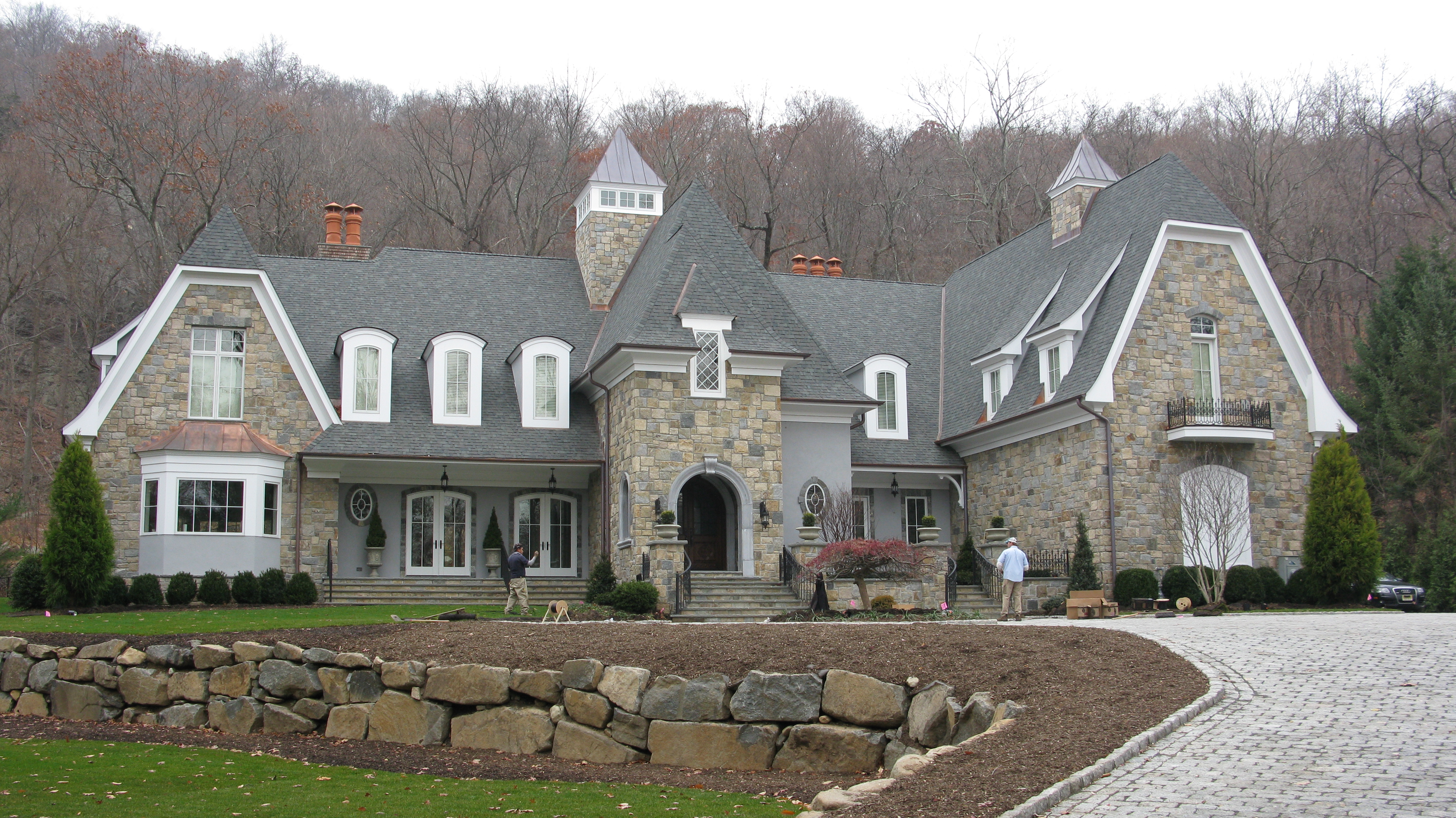 Luxury stone elevation home exterior in a wooded residential setting